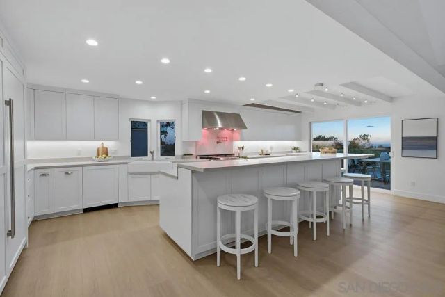 a kitchen with a sink and chairs