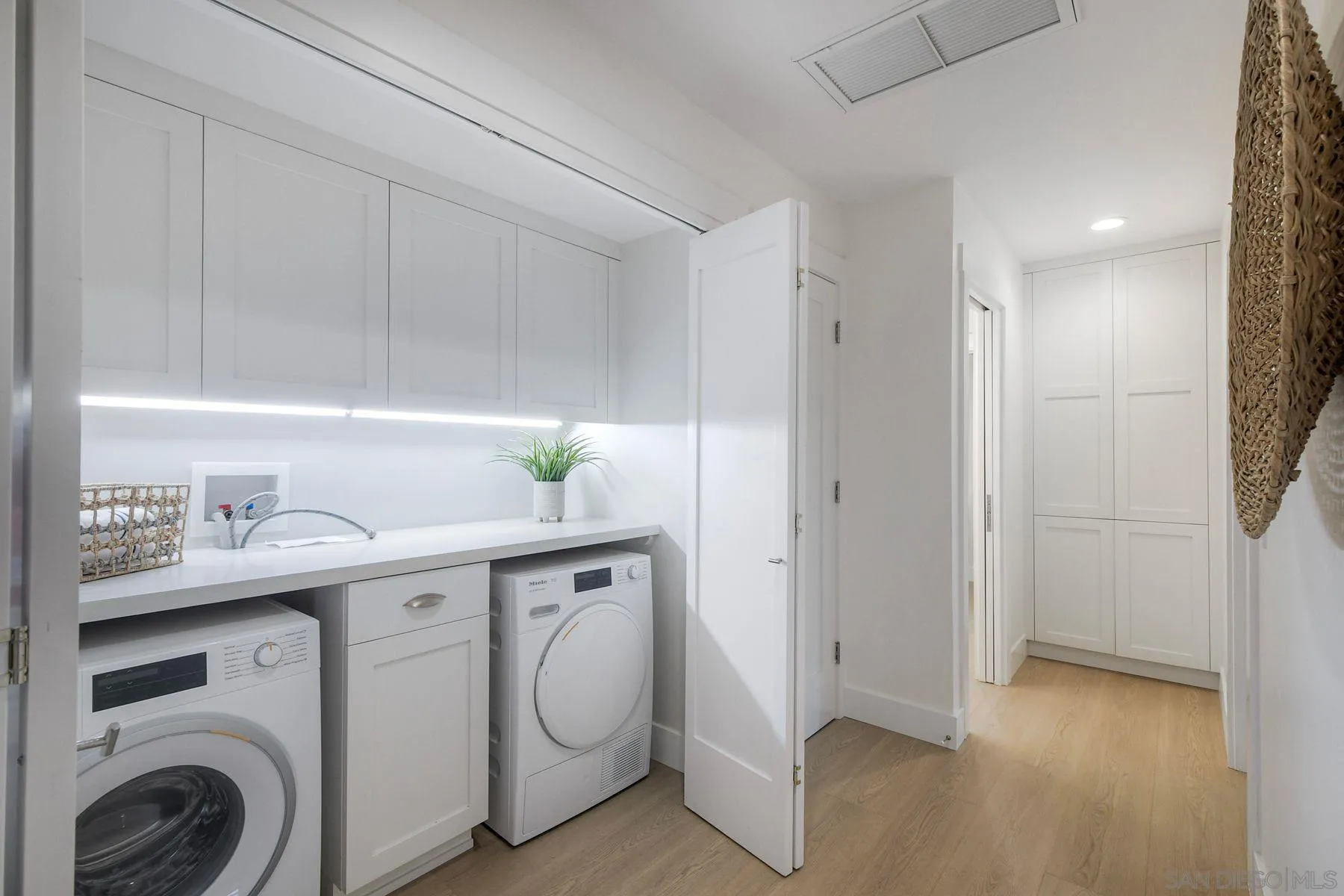 1711 Burgundy Road Encinitas, CA 92024 - Photo 29 of 45 a utility room with cabinets washer and dryer