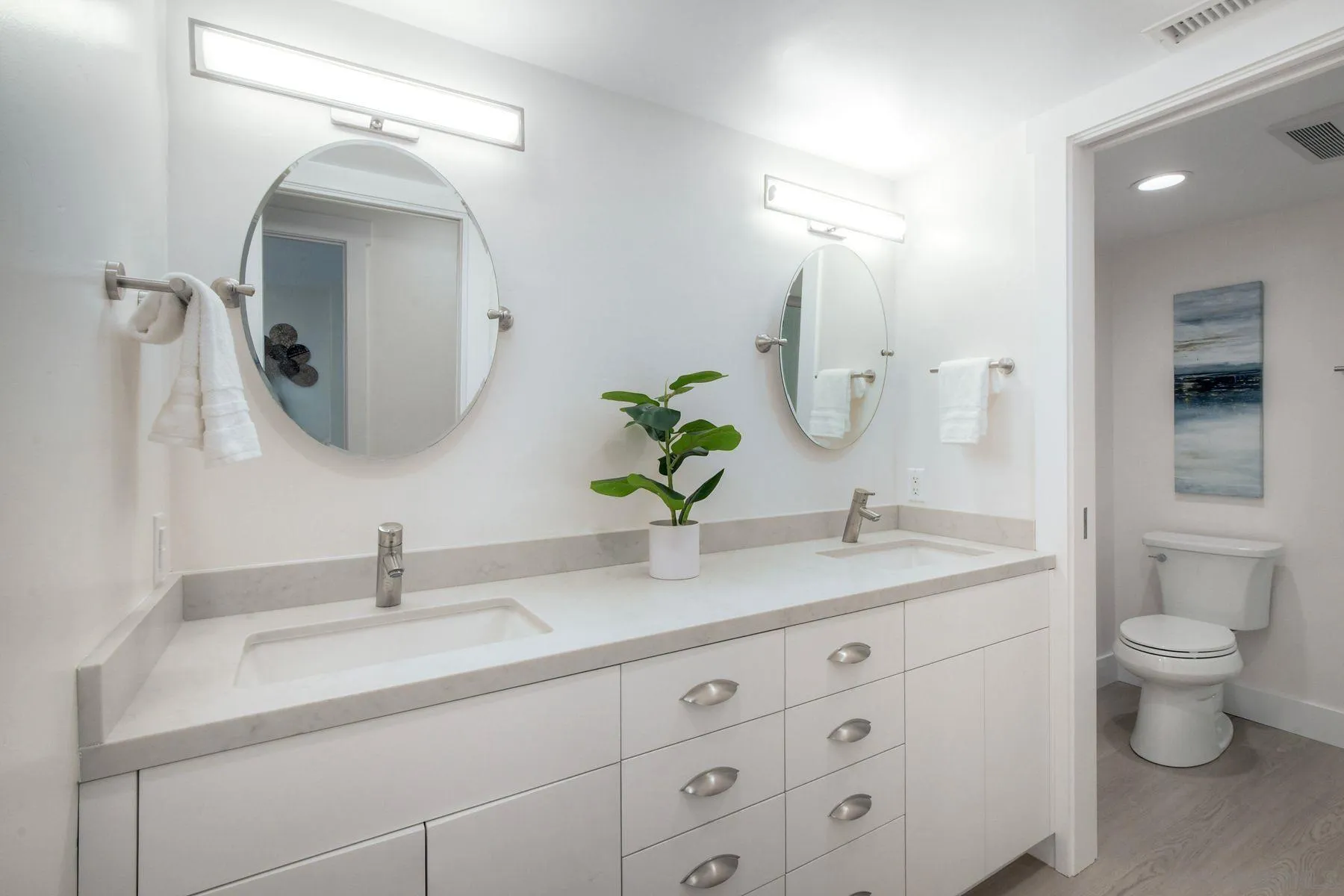 1711 Burgundy Road Encinitas, CA 92024 - Photo 31 of 45 a bathroom with a double vanity sink toilet and a mirror