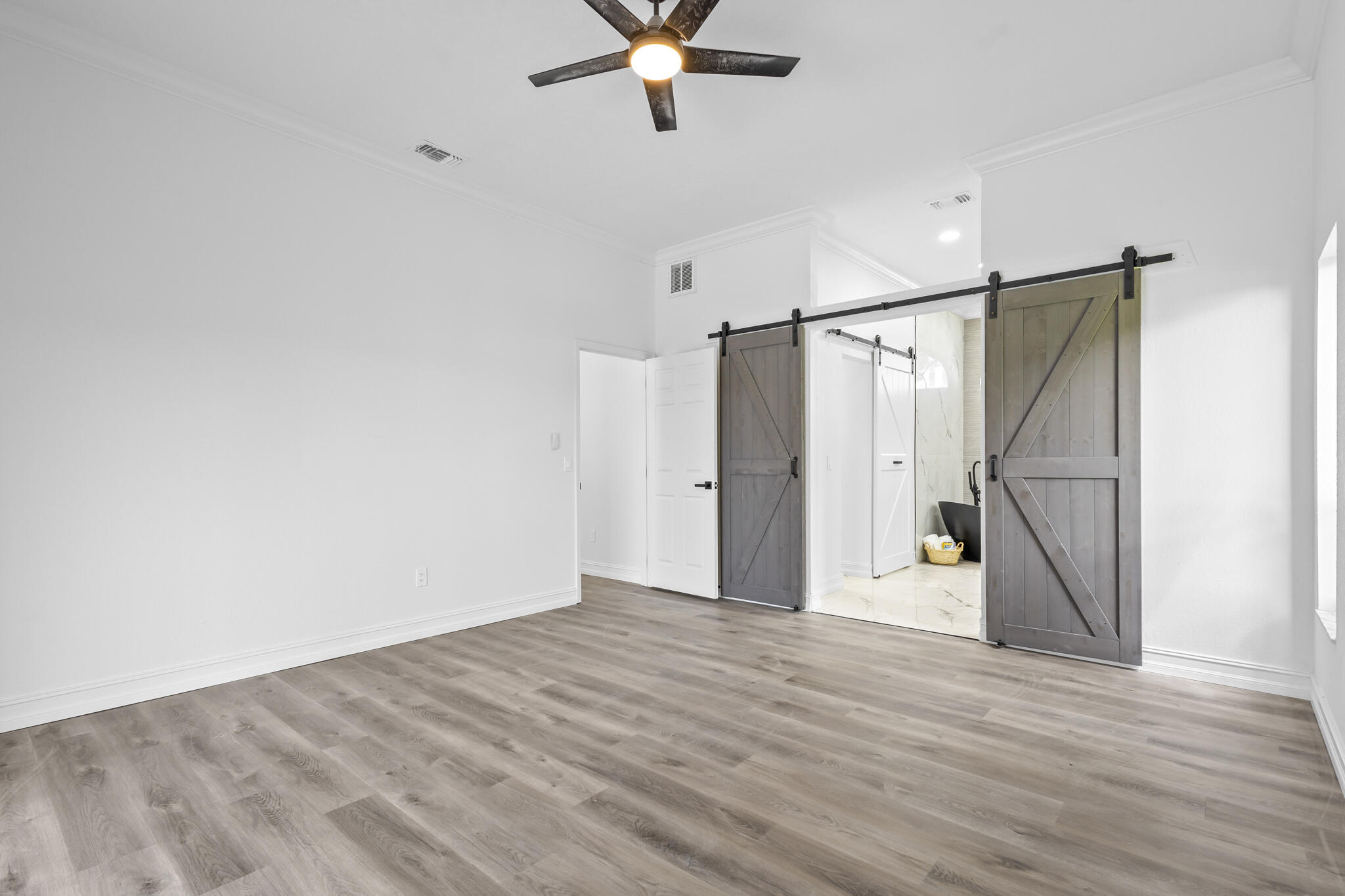 1695 Rustic Way Melbourne, FL 32935 - Photo 12 of 24 a view of an empty room with wooden floor and a ceiling fan