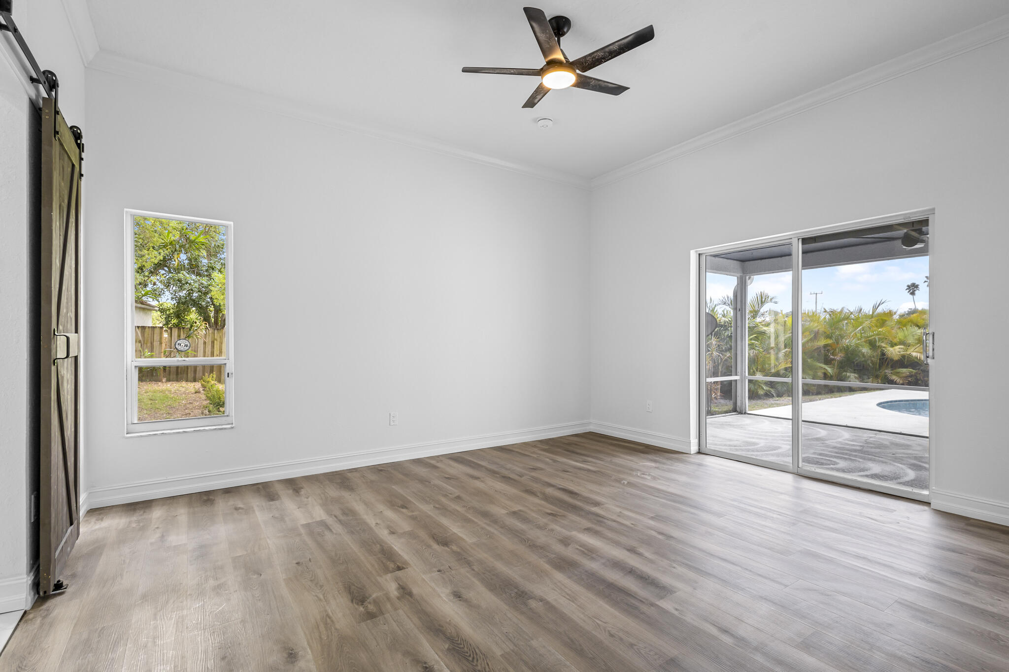 1695 Rustic Way Melbourne, FL 32935 - Photo 13 of 24 an empty room with wooden floor and windows