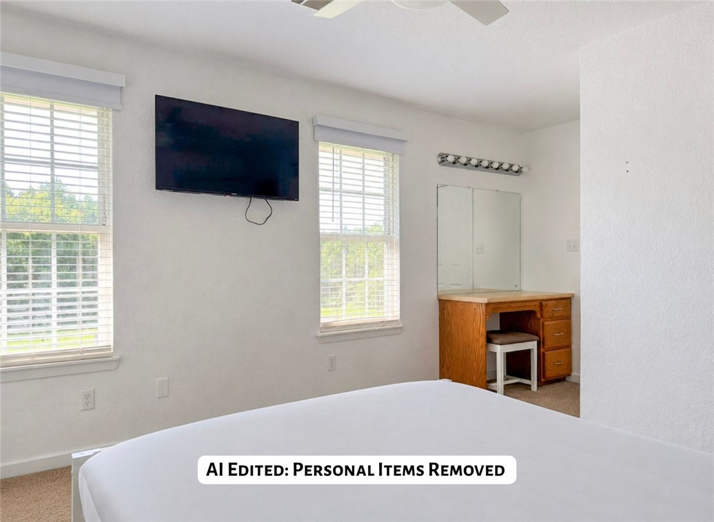 70 Walthall Road Russellville, AR 72802 - Photo 25 of 51 Bright room featuring two windows with horizontal blinds, a ceiling fan, and a built-in wood-finish vanity with a tri-fold mirror and integrated lighting