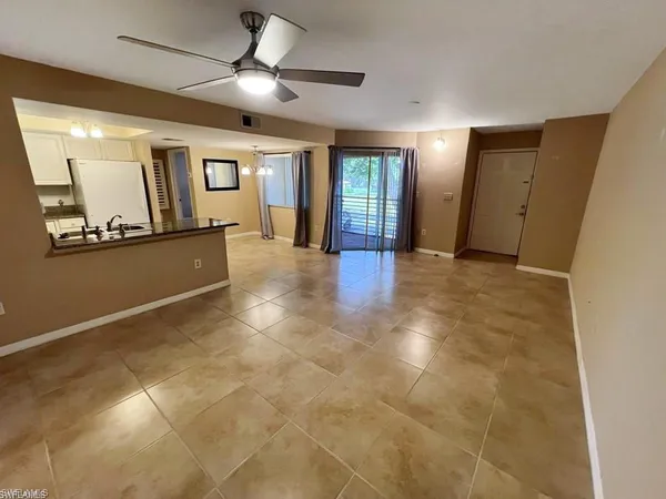 a view of an empty room with window and cabinet