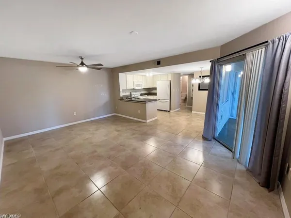 a view of a livingroom with an empty space and a window