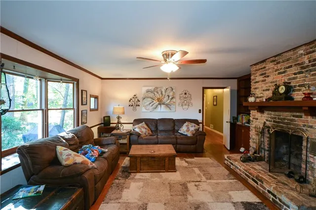 a living room with furniture a fireplace and a floor to ceiling window