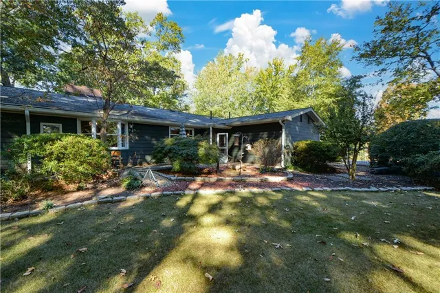 a view of a house with table and chairs in a yard