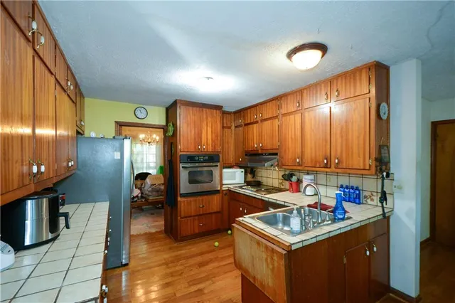 a kitchen that has a lot of cabinets a sink and a stove in it