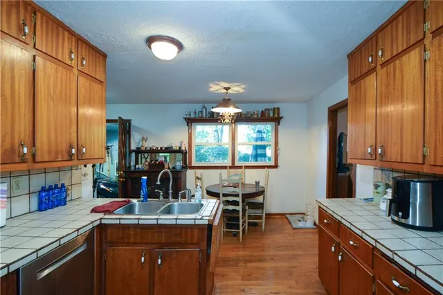 a kitchen with kitchen island granite countertop a sink cabinets and window