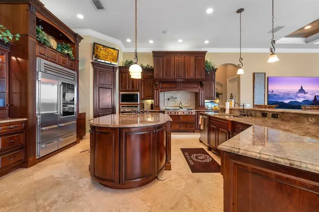 a kitchen with stainless steel appliances granite countertop a sink a stove and a refrigerator