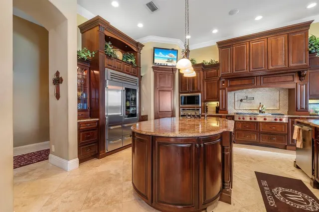 a kitchen with stainless steel appliances granite countertop a stove refrigerator and cabinets