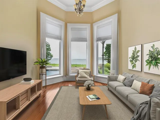 a living room with a large window and chandelier