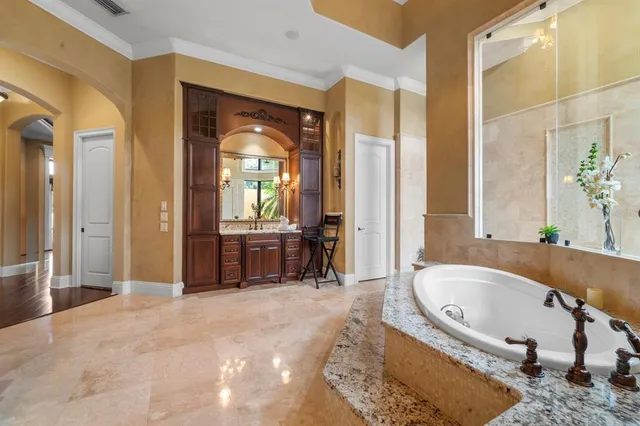 a bathroom with a tub a sink and a large mirror