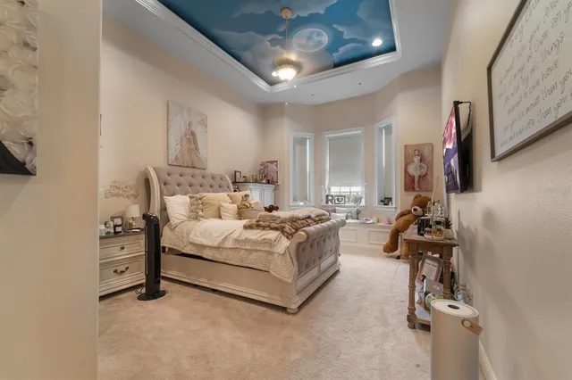 a bedroom with a bed couch and a large window