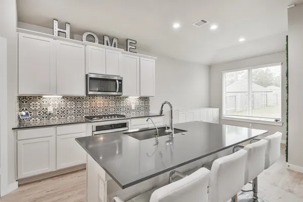 a kitchen with stainless steel appliances granite countertop a sink a microwave and wooden cabinets