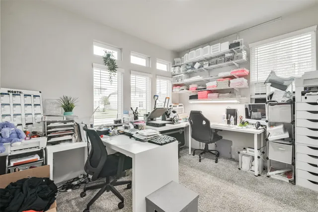 a room with a computer on a desk and chair in it