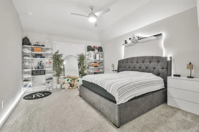 a bedroom with a bed couch and lots of windows