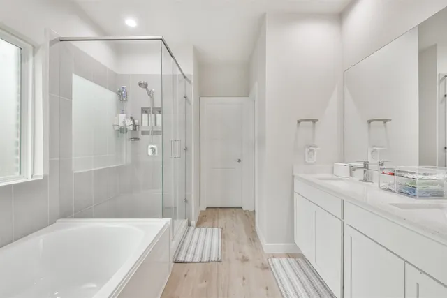 a bathroom with a sink a mirror a bathtub and shower