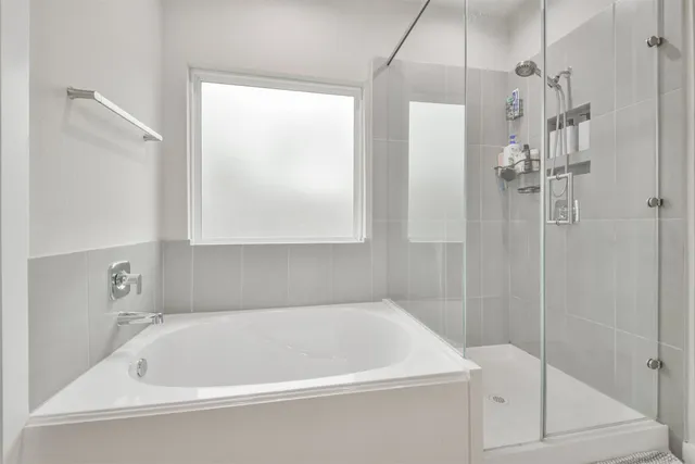 a white bath tub sitting next to a shower