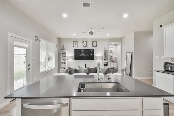a kitchen with kitchen island a sink stainless steel appliances and windows