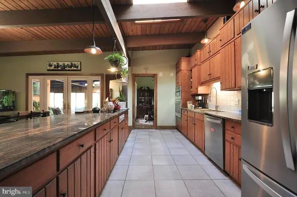 a large kitchen with stainless steel appliances kitchen island granite countertop a large counter top and a stove
