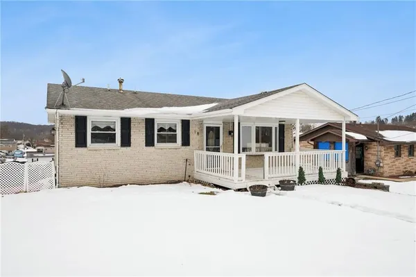 a front view of a house with a yard covered with snow