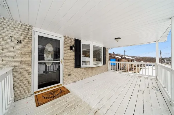 a view of a balcony with floor to ceiling windows and a kitchen view