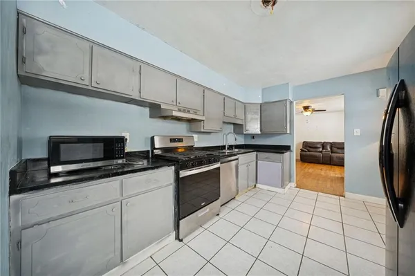 a kitchen with stainless steel appliances granite countertop a stove a sink and a microwave
