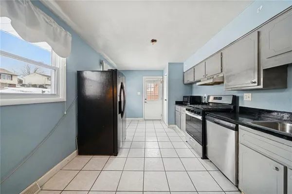 a kitchen with stainless steel appliances granite countertop a refrigerator and a stove