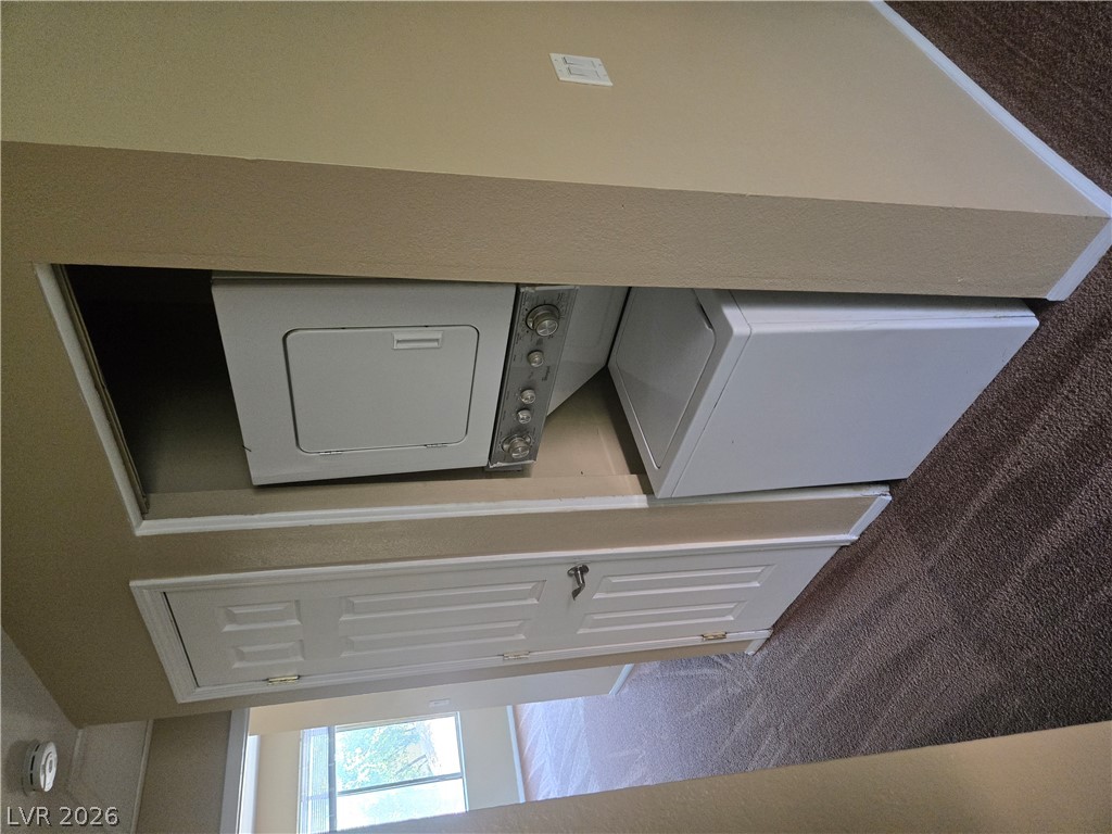 7200 West Pirates Cove Road, Unit 2047 Las Vegas, NV 89145 - Photo 15 of 17 Convenient laundry space features a stacked washer and dryer, optimizing utility in a compact area.