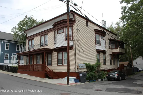 a front view of a house with a garden and parking