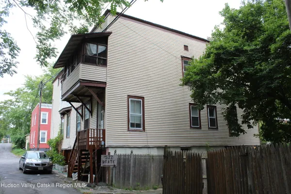 a front view of a house with a tree
