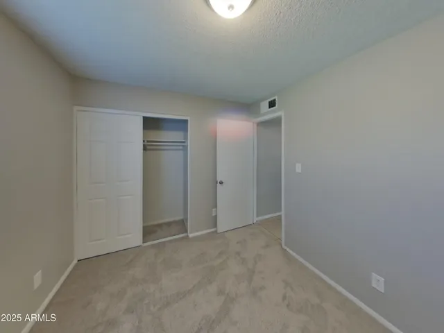 an empty room with windows and closet