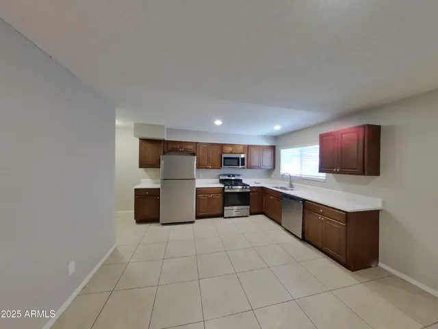 a view of an empty room with chandelier fan