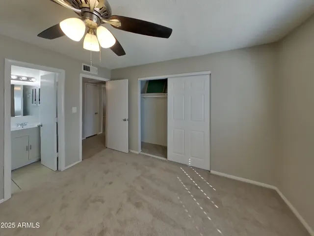 an empty room with a window and a fan