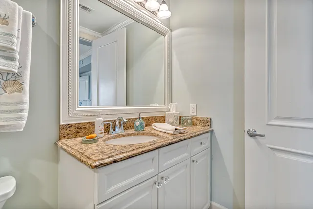 a bathroom with a sink vanity mirror and toilet