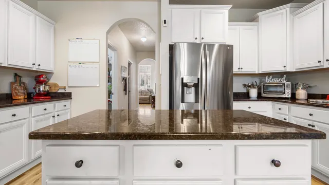a kitchen with granite countertop a sink a stove and cabinets