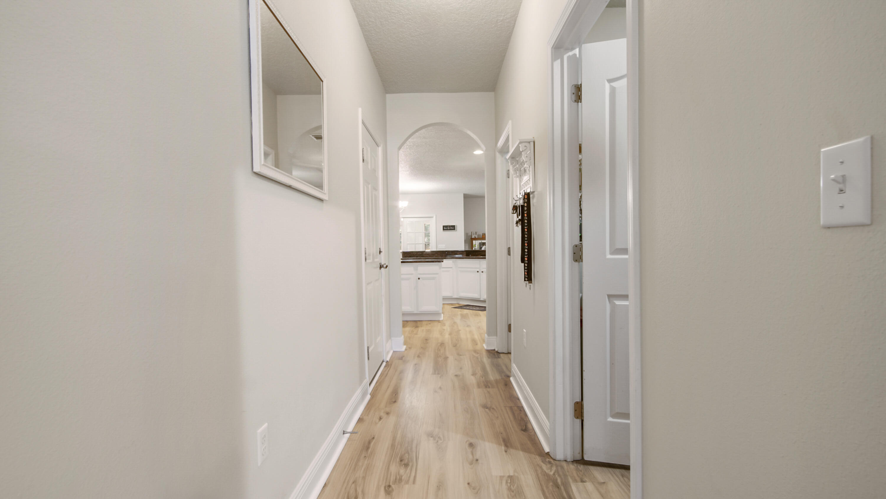 446 Mango Lane Freeport, FL 32439 - Photo 74 of 74 a view of a hallway with wooden floor and a bathroom