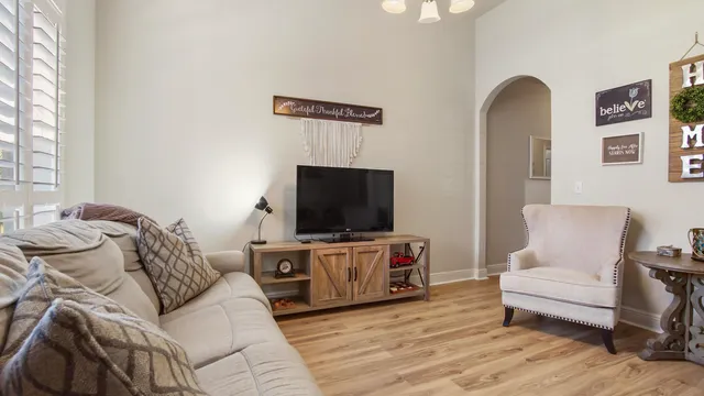 a living room with furniture and a wooden floor