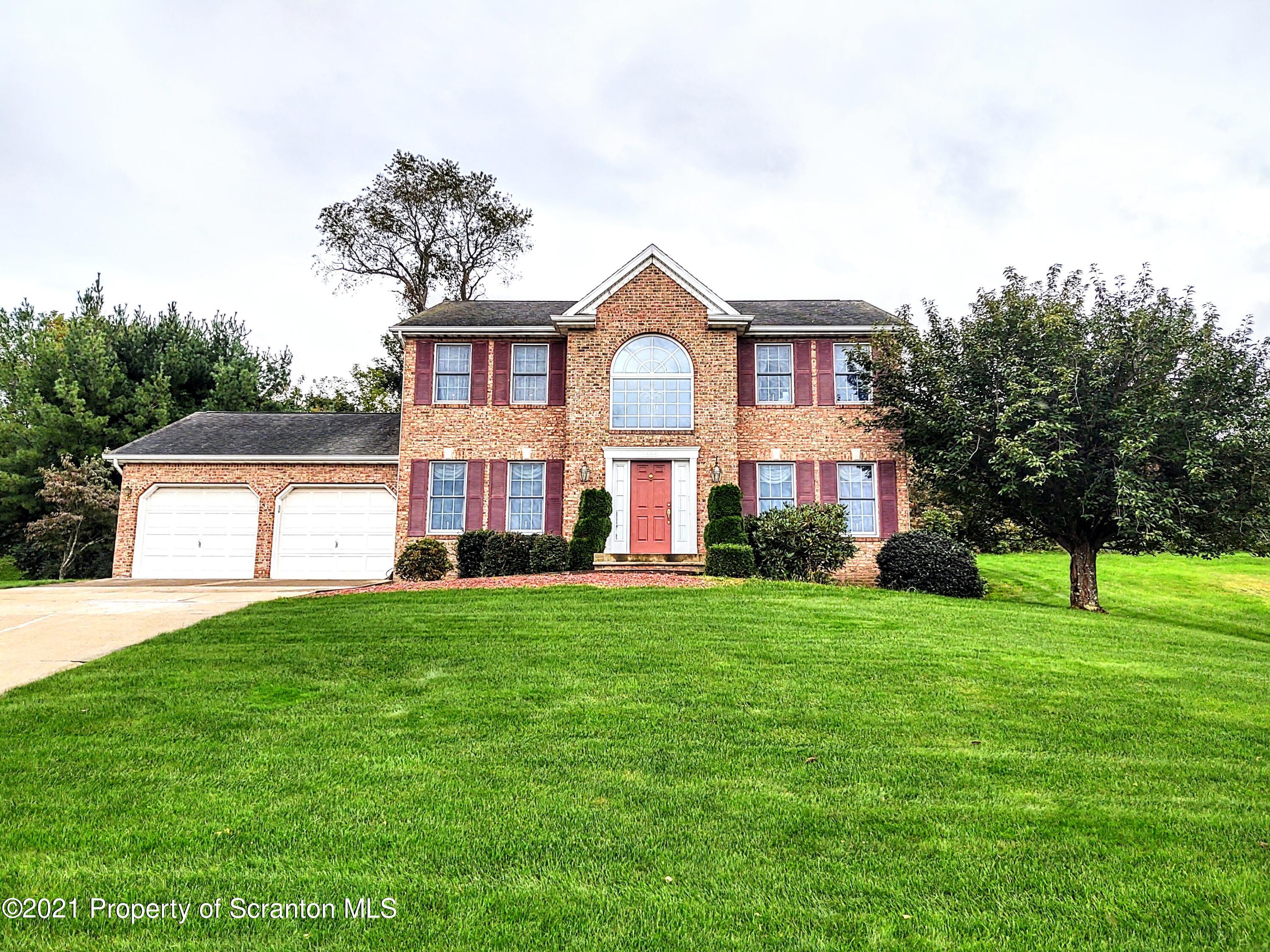 a front view of house with yard and green space