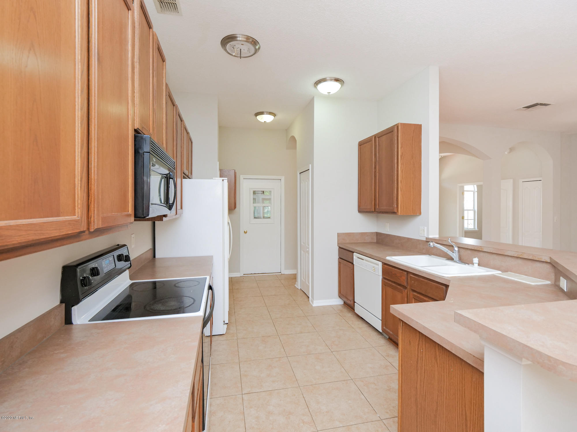 8663 Reedy Branch Drive Jacksonville, FL 32256 - Photo 11 of 33 a large kitchen with a sink and a stove top oven with wooden floor