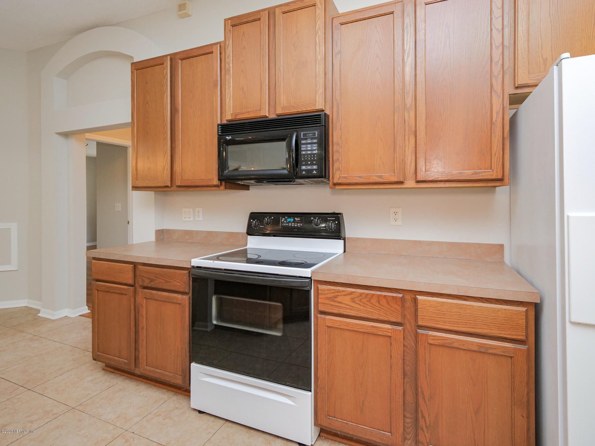 8663 Reedy Branch Drive Jacksonville, FL 32256 - Photo 12 of 33 a kitchen with stainless steel appliances granite countertop white cabinets a microwave a sink and a refrigerator