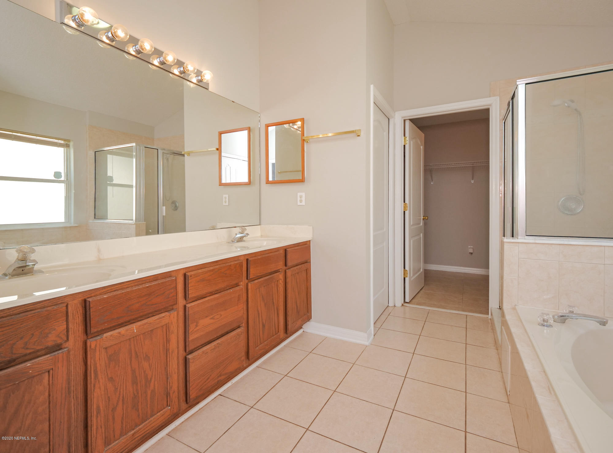 8663 Reedy Branch Drive Jacksonville, FL 32256 - Photo 19 of 33 a spacious bathroom with a granite countertop sink a mirror and a