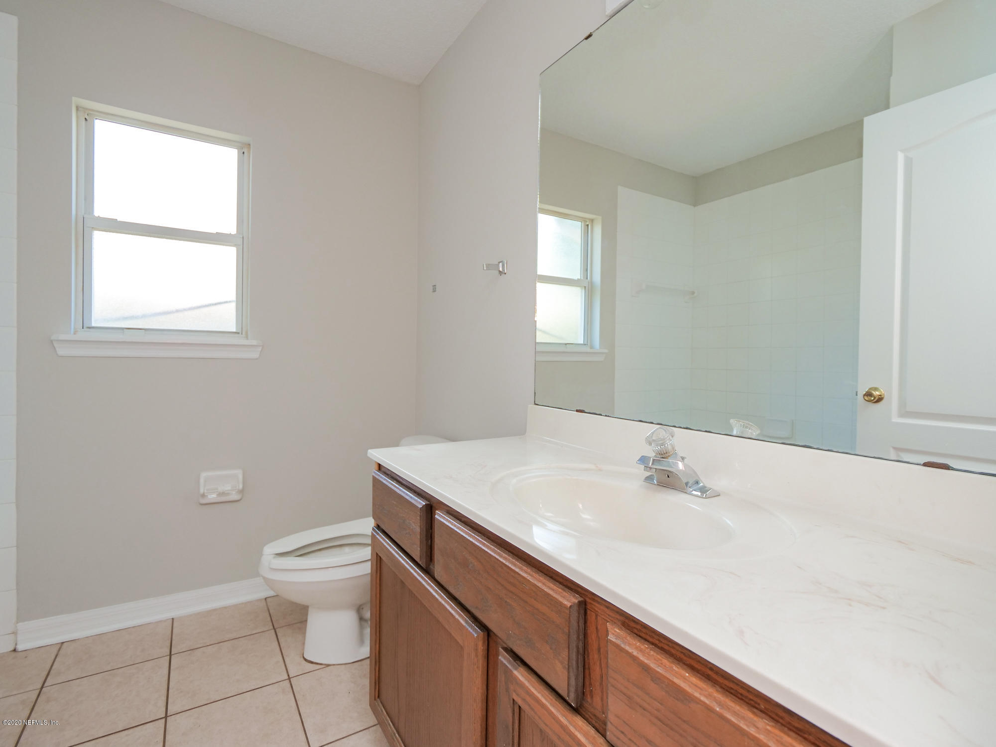8663 Reedy Branch Drive Jacksonville, FL 32256 - Photo 23 of 33 a bathroom with a sink toilet and window