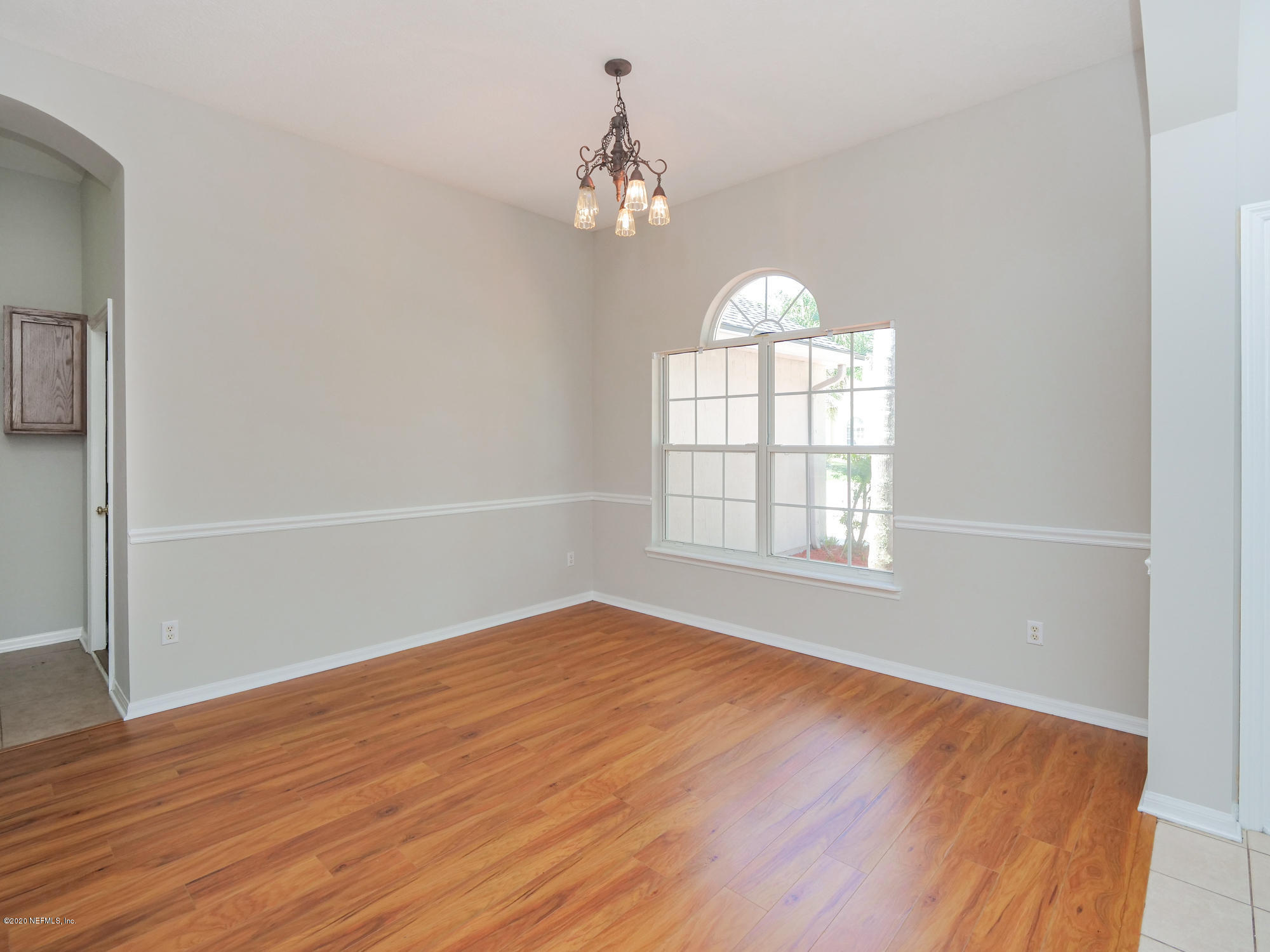 8663 Reedy Branch Drive Jacksonville, FL 32256 - Photo 6 of 33 an empty room with wooden floor chandelier and windows