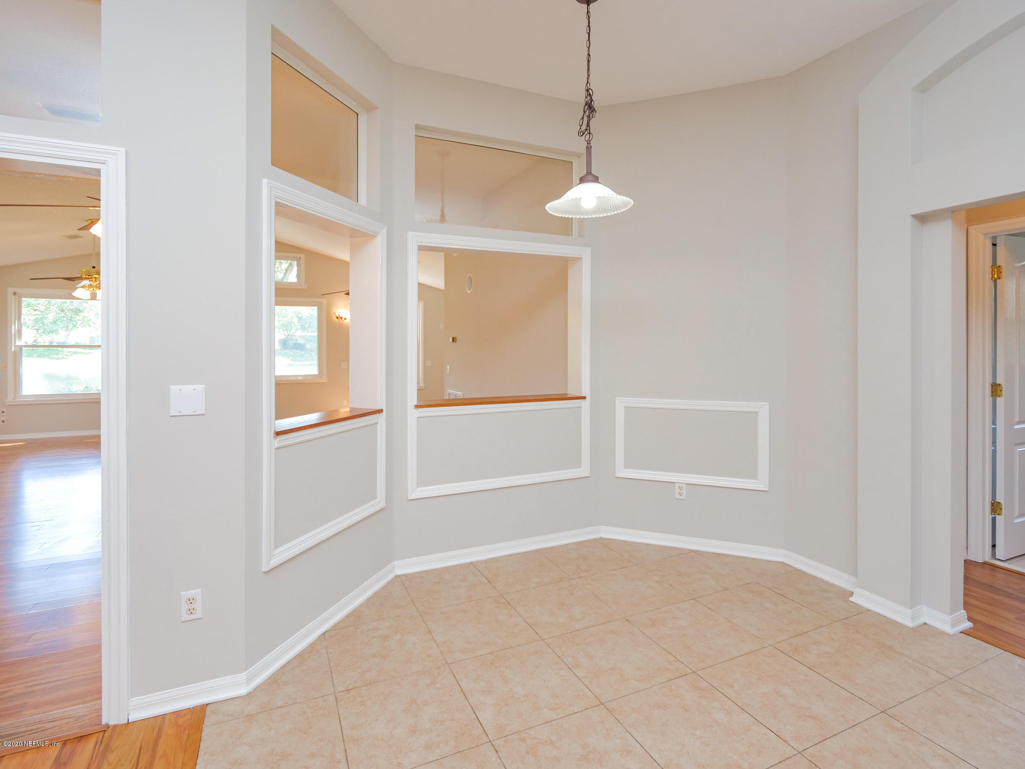 8663 Reedy Branch Drive Jacksonville, FL 32256 - Photo 10 of 33 an empty room with chandelier fan and windows
