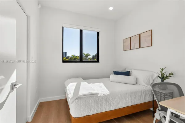 a bedroom with a bed and a potted plant