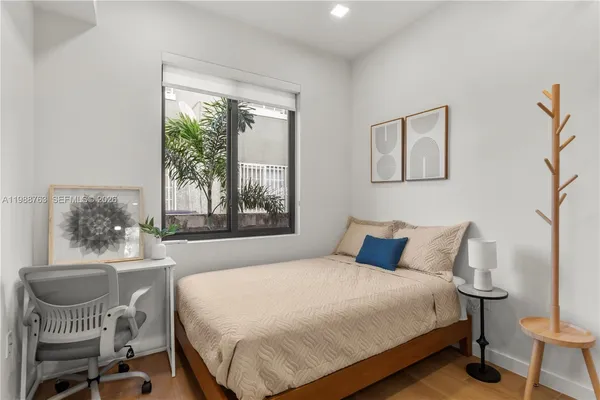 a bedroom with a bed a table and chair