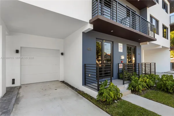 front view of a house with a large window and potted plants
