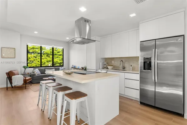 a kitchen with stainless steel appliances granite countertop a sink a stove and a refrigerator
