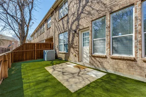 a view of a backyard with wooden fence and large trees